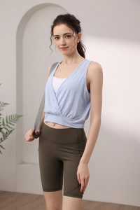 Light blue jacquard yoga tank top with V-neck cross design and olive green biker shorts