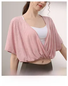 Detail of light pink batwing sleeve sports top showing jacquard breathable fabric texture