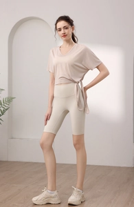 Détail du haut de yoga beige à col en V avec liens et short de fitness taille haute assorti