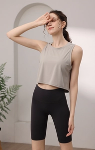 Détail du débardeur de fitness en maille côtelée beige avec short de cyclisme noir taille haute