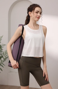 Detail eines weißen ärmellosen Sport-Tops und olivgrüner Leggings mit hoher Taille