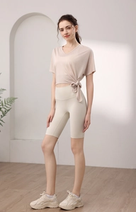 Détail du nœud latéral sur le haut de yoga ample beige avec décolleté en V