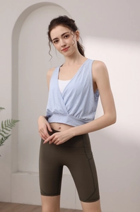 Detail of light blue layered yoga tank top and high waist olive green gym leggings