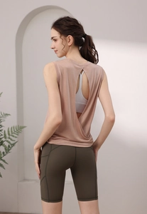 Detail of backless yoga tank top in dusty pink with green high-waisted shorts