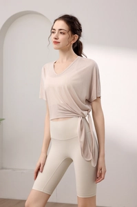 Vue détaillée du cordon de serrage latéral et de la texture douce du haut de yoga beige