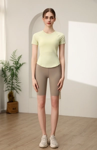 T-shirt sportiva verde chiaro aderente con pantaloncini da ciclista kaki sul modello