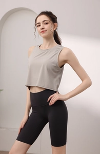 Détail de la texture du débardeur de sport gris chiné et du short de cyclisme à taille haute noir