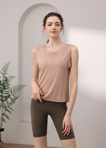 Detail of loose pink backless yoga top with breathable texture and green cycling shorts