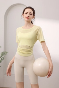 Détail du haut de yoga en tencel jaune clair avec fente latérale et short beige