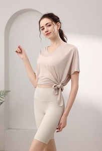 Détail du haut de yoga rose avec col en V, nœud latéral fonctionnel et tissu respirant de qualité