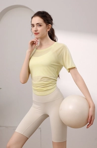Détail du haut de yoga jaune en maille respirante avec une texture légère et fendue