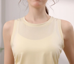 Detailed view of the yellow yoga vest with transparent mesh neckline and slim-fit tencel fabric