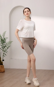 Detail eines weißen Tencel-Yogashirts mit khakifarbener Radlerhose und praktischer Seitentasche