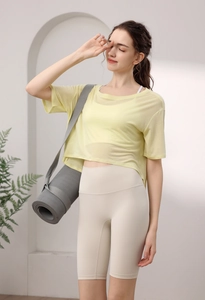 Detail von atmungsaktivem gelbem Mesh-Yoga-Top mit Sport-BH und Radlerhose für Damen