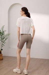 Detail von weißem Yoga-Top und braunen High-Waist Radlerhosen mit praktischen Seitentaschen