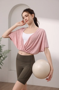 Detail of pink jacquard batwing sleeve yoga top and olive green high waist shorts