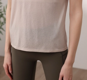 Close-up of loose-fit pink sports top with breathable fabric and green yoga leggings