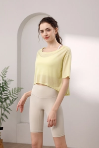 Detailansicht des atmungsaktiven gelben Mesh-Shirts und beige High-Waist Yoga-Shorts