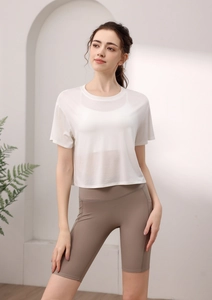 Detailaufnahme des weißen Mesh-Yogashirts und der braunen High-Waist Radlerhose