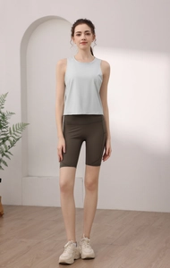 Dettaglio canotta sportiva grigio chiaro e pantaloncini da yoga a vita alta oliva con tasca laterale