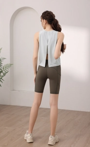 Dettaglio del top verde menta con spacco posteriore e pantaloncini da ciclista olive