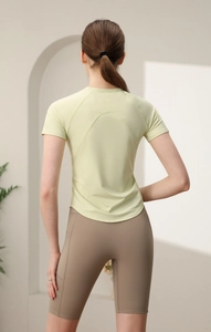 Dettaglio delle cuciture posteriori di una maglietta da yoga verde aderente per fitness