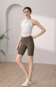Detail view of white breathable tencel sports vest with mesh stitching and green cycling shorts