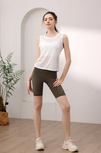 Detailed view of white sleeveless yoga top paired with olive green cycling shorts