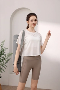 Detail eines atmungsaktiven weißen Netz-T-Shirts und braunen Yoga-Shorts für Damen