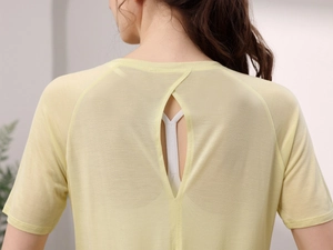 Détail d'un haut de yoga jaune clair avec fente au dos et tissu en maille respirante