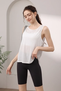 Close-up of white tencel yoga tank top with racerback paired with black cycling shorts