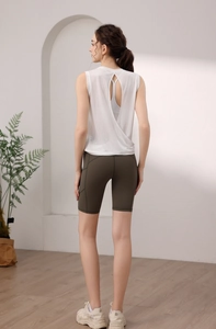 Rear view of white open back yoga top with olive green high waist cycling shorts