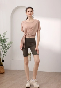 Détail du haut de sport en Tencel rose avec nœud latéral et short de cycliste olive