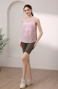 Canotta yoga rosa con schiena scoperta abbinata a pantaloncini da ciclista a vita alta
