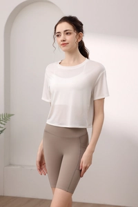 Detail eines weißen Tencel-Sport-T-Shirts und brauner Yoga-Shorts mit hoher Taille