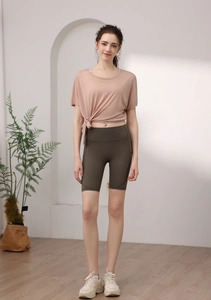 Détail du haut de sport en tencel rose avec nœud latéral et short de cycliste vert