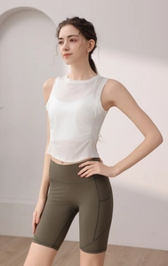 Detail of white tencel yoga tank top and olive green high waist cycling shorts