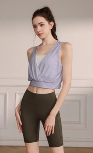 Detail view of lavender V-neck sports vest and high-waisted olive green biker shorts