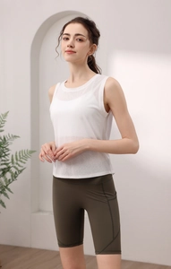 Detail of white breathable yoga tank top and olive green high-waisted cycling shorts