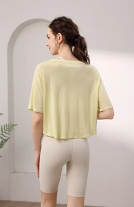 Rückansicht eines atmungsaktiven hellgelben Kurzarm-Yoga-Tops im lockeren Design