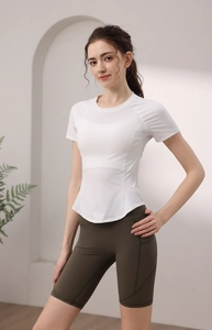 Dettaglio top fitness con bordo curvo e pantaloncini da ciclista oliva con tasca laterale