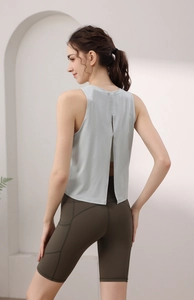 Dettaglio canotta yoga grigia con retro aperto e pantaloncini da corsa verdi su modella