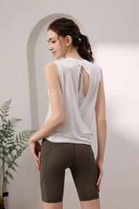 Detail of white backless yoga top with olive green gym shorts featuring side pockets
