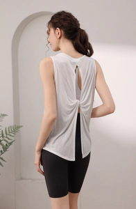 Detail of white yoga tank top featuring an open back split with stylish twist knot design