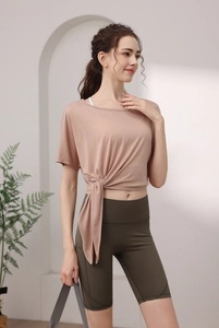 Détail du haut de yoga en Tencel rose avec nœud latéral et short cycliste vert olive