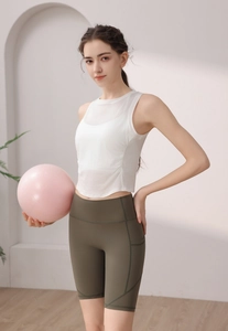 Detail of white mesh tank top and olive high-waisted shorts with side phone pockets