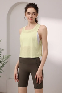 Modell trägt ein gelbes Yoga-Tanktop und olivgrüne Biker-Shorts für atmungsaktiven Komfort