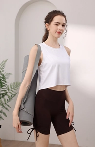 Détail du débardeur côtelé blanc avec short marron à cordon et tapis de yoga