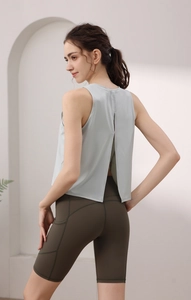 Dettaglio del top da yoga grigio con schiena scoperta e pantaloncini da ciclista verdi