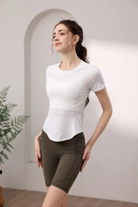 Dettaglio del top da yoga bianco in nylon ad asciugatura rapida e pantaloncini verdi oliva